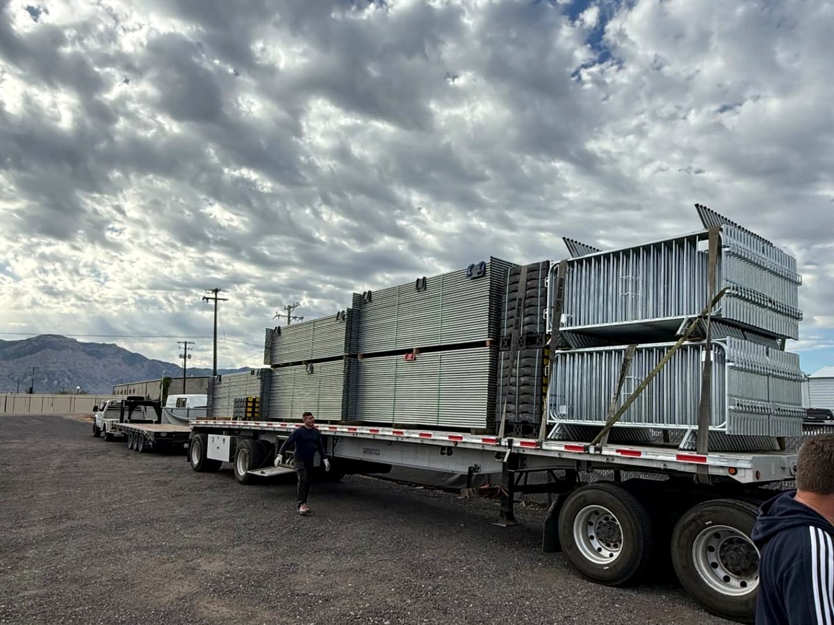 Flatbed trailer loaded with temporary fence panels, bases and barricades ready for delivery